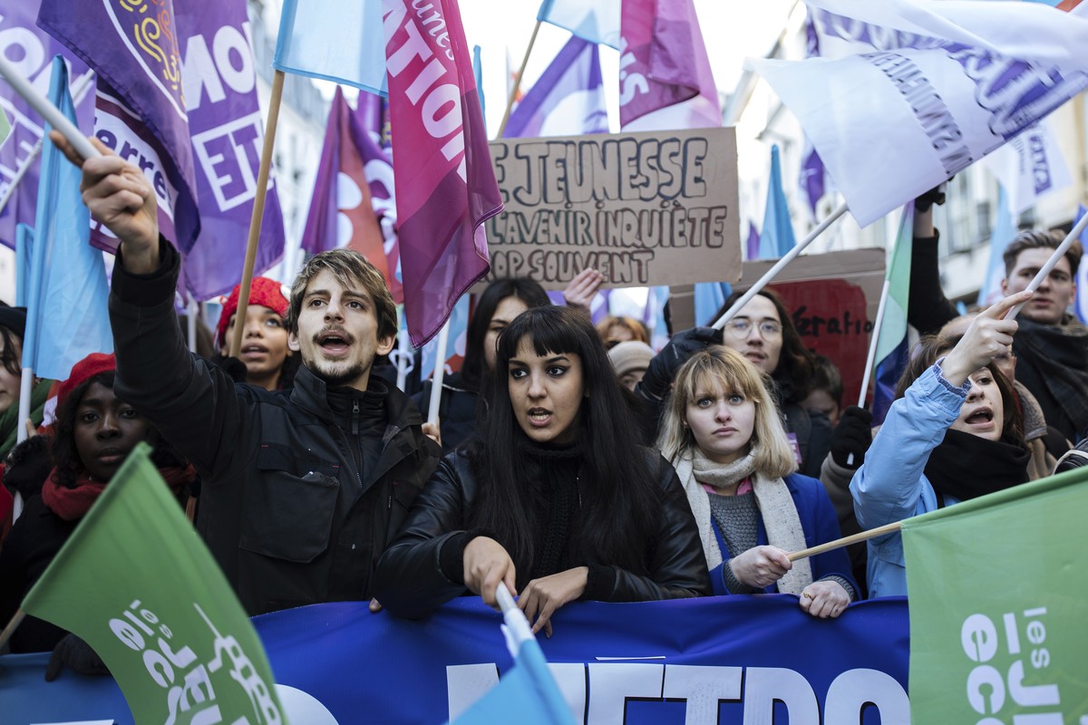 Protestors wave flags during a rally, called by left-wing La France Insoumise (LFI) party and Youth organizations, to protest against the French President's pension reform, in Paris, Saturday, Ja ...