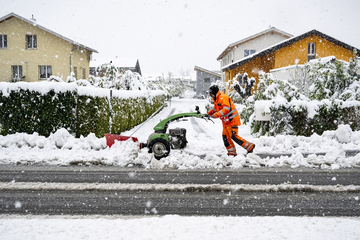 epa12036356 A municipal employee removes snow from a road with a machine in Saillon, Canton Valais, Switzerland, 17 April 2025. Storms brought flooding, landslides, heavy snow, and fallen trees to Val ...