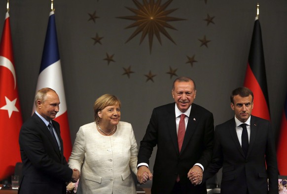 From left, Russian President Vladimir Putin, German Chancellor Angela Merkel, Turkey&#039;s President Recep Tayyip Erdogan and French President Emmanuel Macron pose at the end of a news conference fol ...