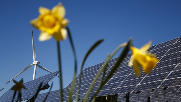 A wind turbine from the JUVENT power plant and solar panels from the solar station of the Mont-Soleil are pictured on the Mont-Soleil in Saint-Imier, Switzerland on Wednesday May 10, 2017. The Swiss p ...