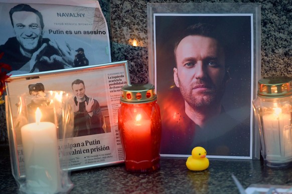 epa11192155 Candles are placed next to photos of Russian opposition leader Alexei Navalny in Gijon, Asturias, northern Spain, 01 March 2024. Outspoken Kremlin critic Navalny died aged 47 in an arctic  ...
