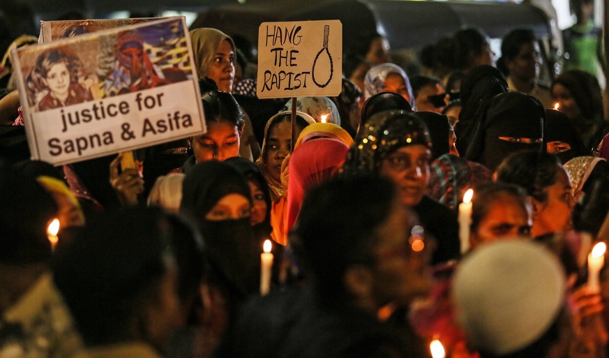 epa06673683 People hold candles and placards during a candle-light protest march against the alleged rape cases in Uttar Pradesh and Jammu and Kashmir, in Mumbra on the outskirts of Mumbai, India, 16  ...