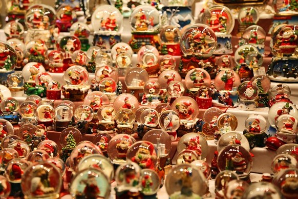 A large variety of Santa Claus-themed snow globes for sale at a Düsseldorf Christmas market.