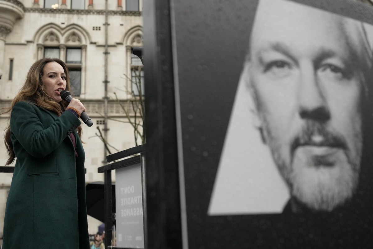 Stella Assange, wife of Julian Assange, speaks besides a poster of Julian Assange at the Royal Courts of Justice in London, Wednesday, Feb. 21, 2024. Julian Assange's lawyers are on their final U ...