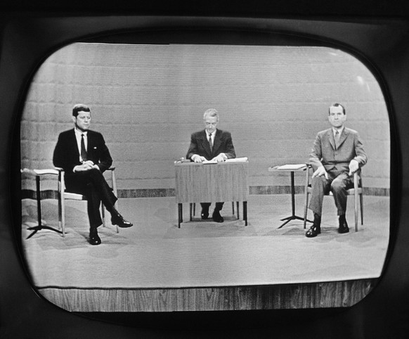 FILE - In this Sept. 26, 1960 file photo, moderator Howard K. Smith sits between, Sen. John Kennedy, left, and Vice President Richard Nixon as they appear on television studio monitor set during their ...
