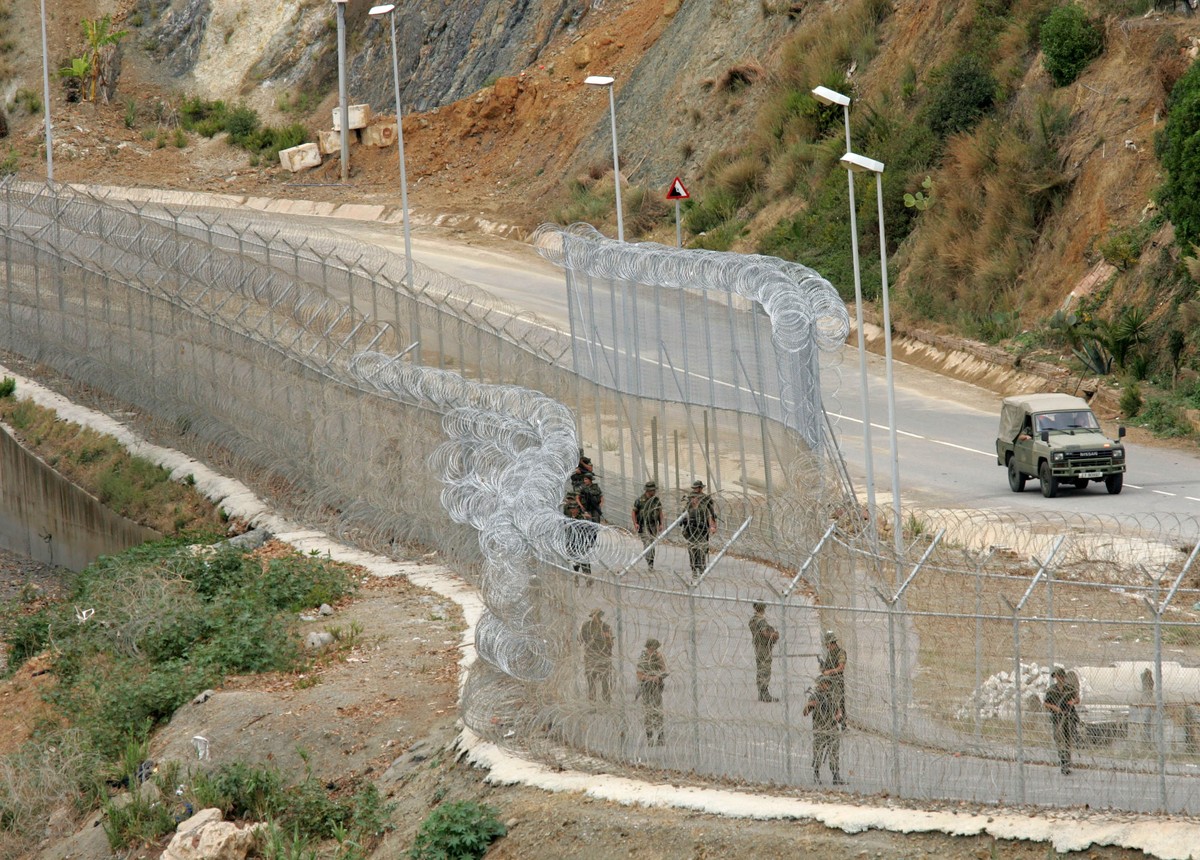 Soldiers patrol the razor wired fences seperating Morocco and Spain's North African enclave of Ceuta on the Moroccan border, Monday, Oct. 3, 2005. Soldiers with automatic weapons and police with  ...
