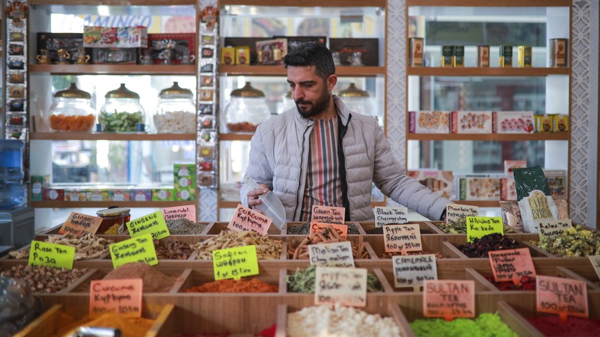 Spice shop owner, Nurullah Ekinciler, works in his shop, in a tourist shopping area in Belek, Antalya, Turkey, Saturday, March 12, 2022. After losing two years to the COVID-19 pandemic, shopkeepers in ...