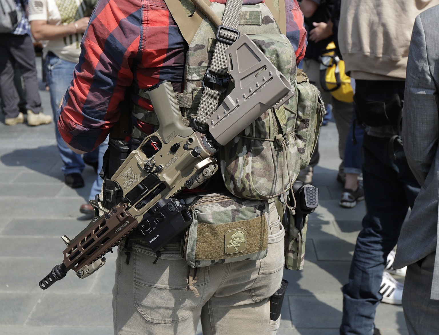 A man standing with members of Patriot Prayer and other groups supporting gun rights wears guns during a rally, Saturday, Aug. 18, 2018, at City Hall in Seattle. (AP Photo/Ted S. Warren)