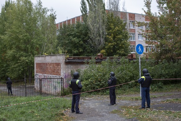 epa10207190 Russian policemen work near the scene of a school shooting at school 88 in Izhevsk, Russia, 26 September 2022. The shooting began during class when an unidentified man in a black suit burs ...