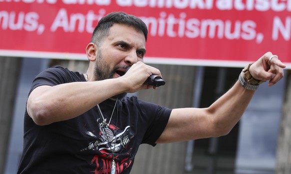 epa08540647 German vegan chef Attila Hildmann, speaks to his followers during an anti-restrictions protest at the Lustgarten park in Berlin, Germany, 11 July 2020. Hildmann supporters demonstrate main ...