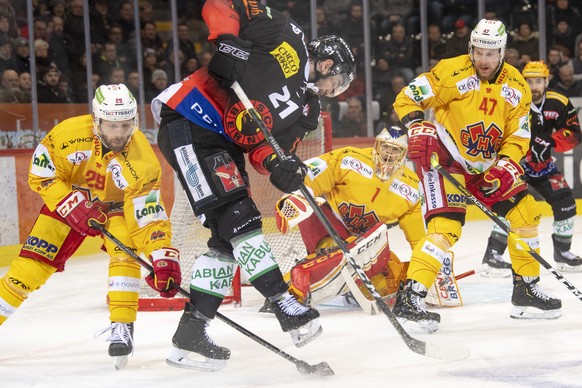 Berns, Simon Moser, Mitte, kaempft um den Puck, gegen Biels, Beat Forster, links und Goalie Jonas Hiller, Mitte rechts, und Biels, Marco Maurer, rechts, waehrend dem ersten Playoff Halbfinalspiel der  ...