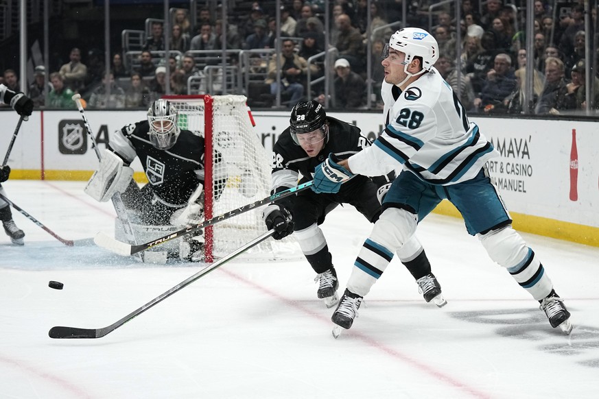 San Jose Sharks right wing Timo Meier, right, passes the puck while under pressure from Los Angeles Kings center Jaret Anderson-Dolan, center, as goaltender Pheonix Copley watches during the third per ...