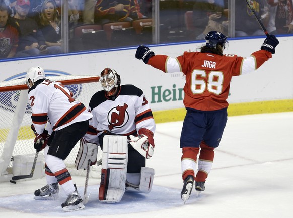 Florida Panthers right wing Jaromir Jagr (68) celebrates a goal by Jonathan Marchessault against New Jersey Devils goalie Cory Schneider, center, during the first period of an NHL hockey game, Thursda ...