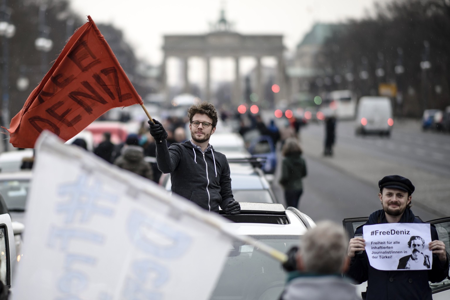 epa05804058 Protestors wave flags and hold sheets reading &#039;Free Deniz&#039; during a motorcade on the occasion of the solidarity for the German-Turkish journalist Deniz Yucel in Berlin, Germany,  ...