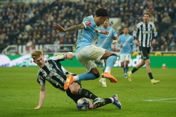 Newcastle's Lewis Hall, left, and Manchester City's Savinho fight for the ball during the fifth round FA Cup soccer match between Newcastle and Manchester City in Newcastle, England, Saturda ...