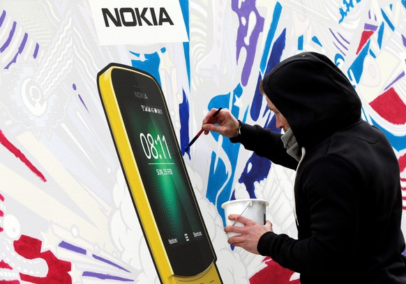 epa06566461 An artist paints Nokia's new 8110 smartphone at the company's stand at the Mobile World Congress (MWC) is taking place in Barcelona, Spain, 26 February 2018. The MWC will be held ...