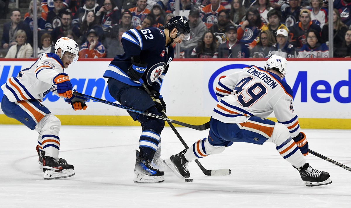 Edmonton Oilers' Vasily Podkolzin (92) and Ty Emberson (49) battle with Winnipeg Jets' Nino Niederreiter (62) for the puck during second period NHL action in Winnipeg, Sunday April 13 2025.  ...