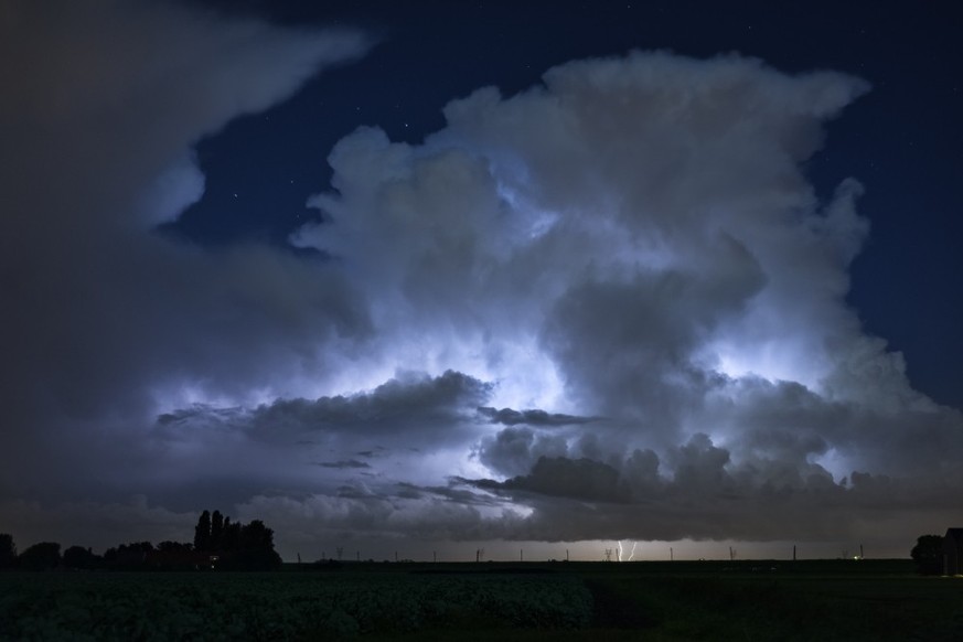 Aufleuchtende Wolken bei einem Gewitter über der Nordsee.