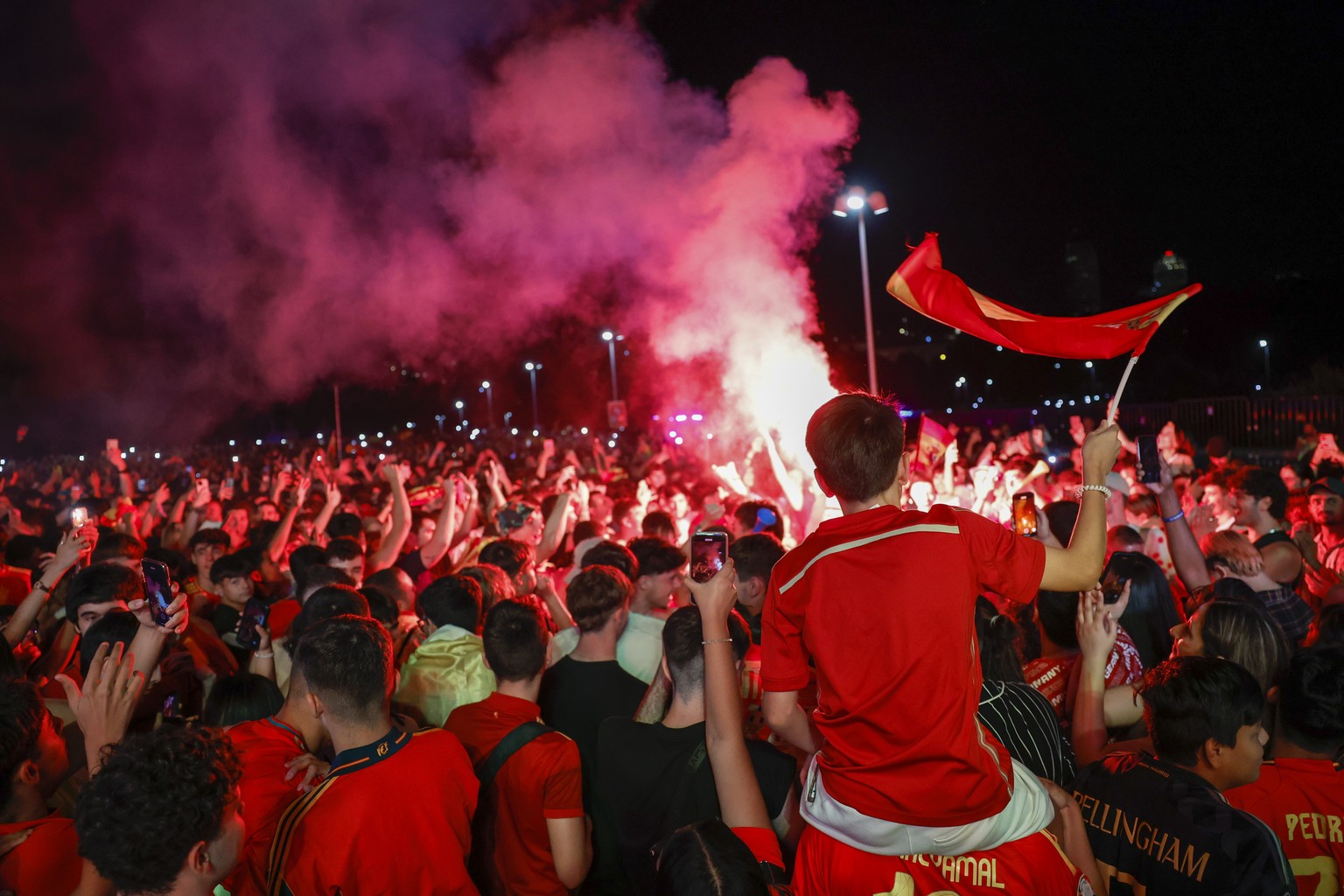 epa11469431 Fans of the Spanish national soccer team celebrate their team winning while watching the UEFA Euro 2024 semi final soccer match between Spain and France on a giant screen at Puente del Rey ...