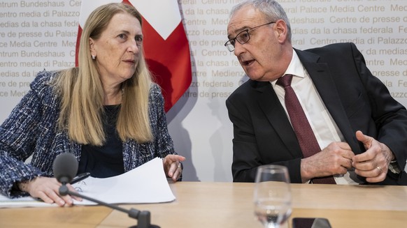 Swiss Federal Councillor Guy Parmelin, right, and Helene Budliger Artieda, State secretary for economy, talk after informing during a press conference on the new import tariffs into the US, Friday, No ...