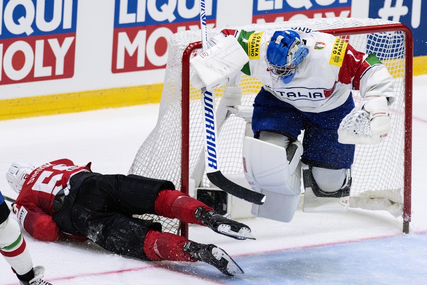 epa09946972 Switzerland&#039;s Dario Simion (L) in action against Italy&#039;s goalkeeper Andreas Bernard during the group A match between Switzerland and Italy at the IIHF Ice Hockey World Championsh ...