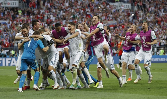 Russian teammates rush to hug and congratulate Russia goalkeeper Igor Akinfeev, left after he makes the a save during a penalty shoot out that send Russia to the quarterfinals during the round of 16 m ...