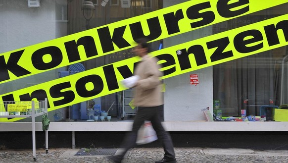 Ein Mann geht am Dienstag, 9. Juni 2009, in Berlin an einem Geschaeft mit Werbeschildern mit der Aufschrift &quot;Konkurse, Insolvenzen&quot;, das Artikel aus Geschaeftsaufloesungen verkauft, vorbei.  ...