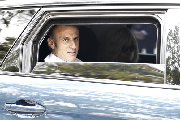 French President Emmanuel Macron and his wife Brigitte Macron leave after voting for the second round of the legislative elections in Le Touquet-Paris-Plage, northern France, Sunday July 7 2024. Votin ...