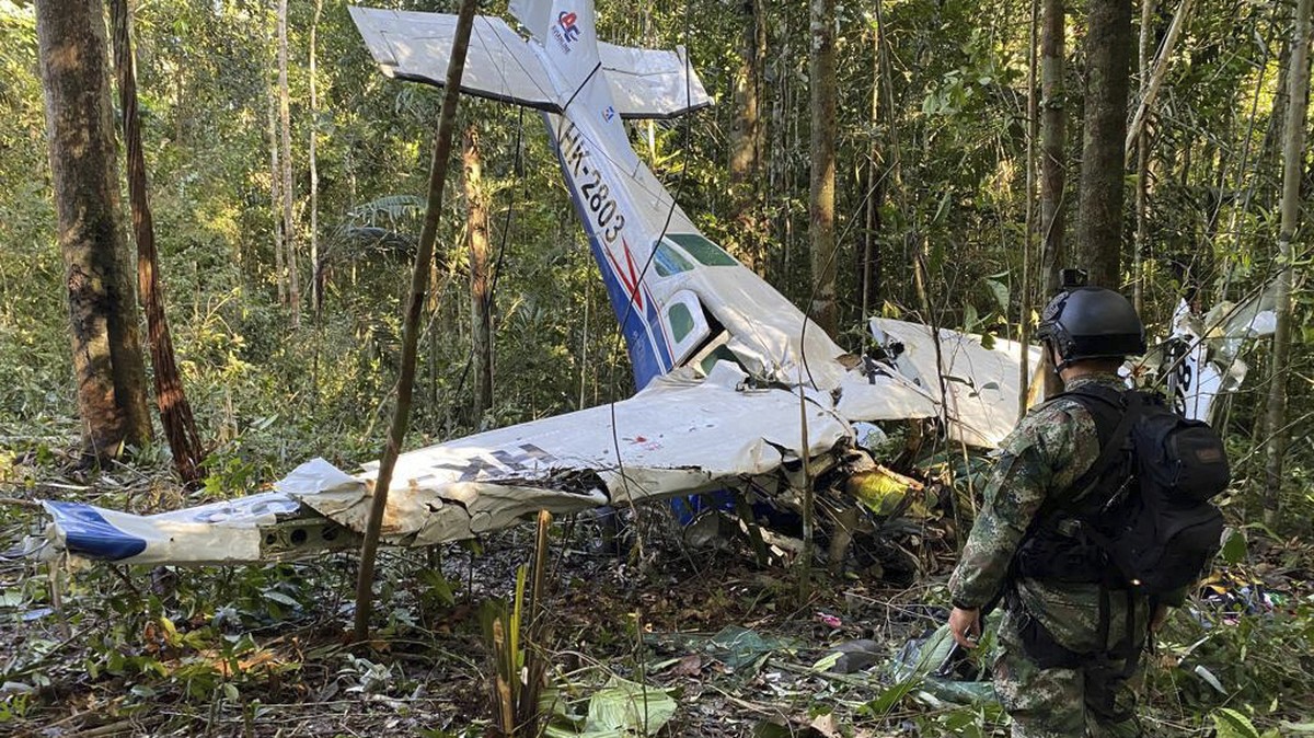 FILE - In this photo released by Colombia's Armed Forces Press Office, a soldier stands in front of the wreckage of a Cessna C206, May 18, 2023, that crashed in the jungle of Solano in the Caquet ...