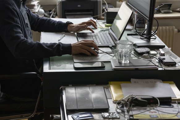 ZUM THEMA HOMEOFFICE STELLEN WIR IHNEN FOLGENDES NEUES BILD ZUR VERFUEGUNG. WEITERE BILDER FINDEN SIE AUF visual.keystone-sda.ch --- Ein Mann arbeitet mit Laptop und Bildschirm im Homeoffice, fotograf ...