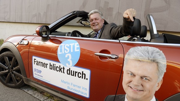 Der Zuercher FDP-Nationalratskandidat Martin Farner strahlt in seinem Walkampfauto beim Wahlauftakt der FDP des Kanton Zuerich in Dietlikon am Mittwoch, 26. August 2015. (KEYSTONE/Walter Bieri)