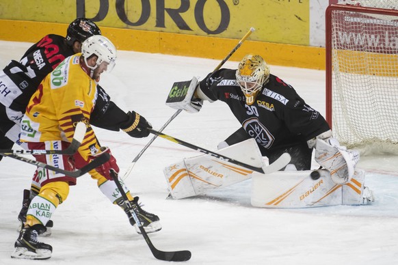 From left, Lugano&#039;s player Giovanni Morini, Tiger&#039;s player Anthony Huguenin and Lugano&#039;s goalkeeper Elvis Merzlikins, during the preliminary round game of National League Swiss Champion ...