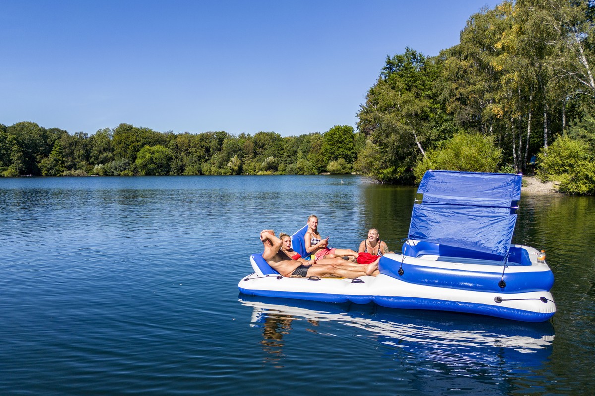05.09.2023, Nordrhein-Westfalen, Duisburg: Menschen lassen sich auf ihrer Badeinsel in Duisburg in der Sonne �ber einen See treiben. Der Hochsommer ist zur�ck in Nordrhein-Westfalen - und soll erst ei ...