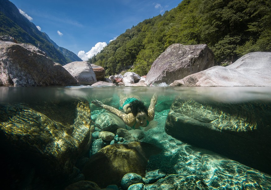 epaselect epa06146760 A young woman dives in the Verzasca river in the Valle Verzasca, Ticino canton, Switzerland, 15 August 2017 (issued 16 August 2017). Numerous people enjoyed the warm weather and  ...