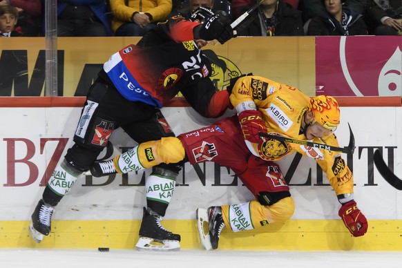 Berns Simon Moser, links, und Langnaus Topscorer Langnaus Harri Pesonen, rechts, kaempfen um den Puck, beim Eishockey Meisterschaftsspiel der National League zwischen dem SC Bern und den SCL Tigers, i ...