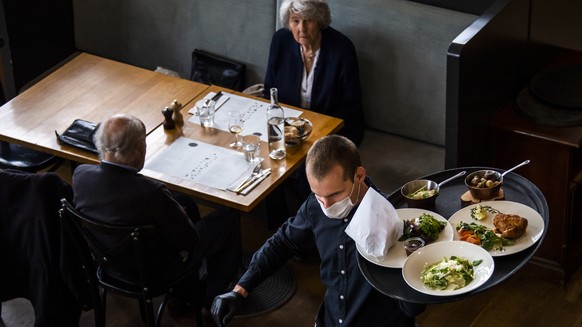 ARCHIVBILD ZUR GEPLANTEN OEFFNUNG DER INNENBEREICHE DER RESTAURANTS AB 31. MAI 2021 - A waiter of &quot;La Brasserie de Montbenon&quot; restaurant brings dishes food to customers during the spread of  ...