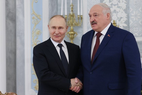 epa11366149 Russian President Vladimir Putin (L) and Belarusian President Alexander Lukashenko attend a meeting at the Palace of Independence in Minsk, Belarus, 24 May 2024. Vladimir Putin said that d ...