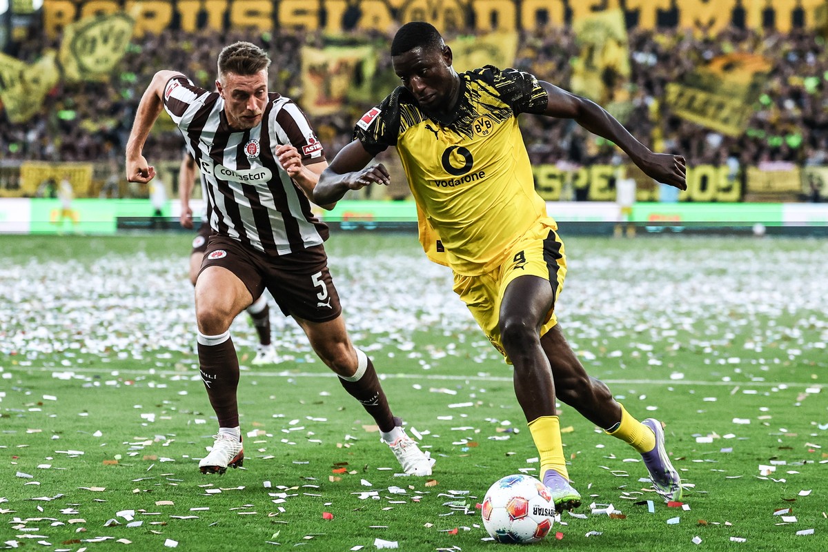 epa12318657 Serhou Guirassy (R) of Dortmund in action against Hauke Wahl of St.Pauli during the German Bundesliga soccer match between St. Pauli vs Borussia Dortmund' in Hamburg, Germany, 23 Augu ...