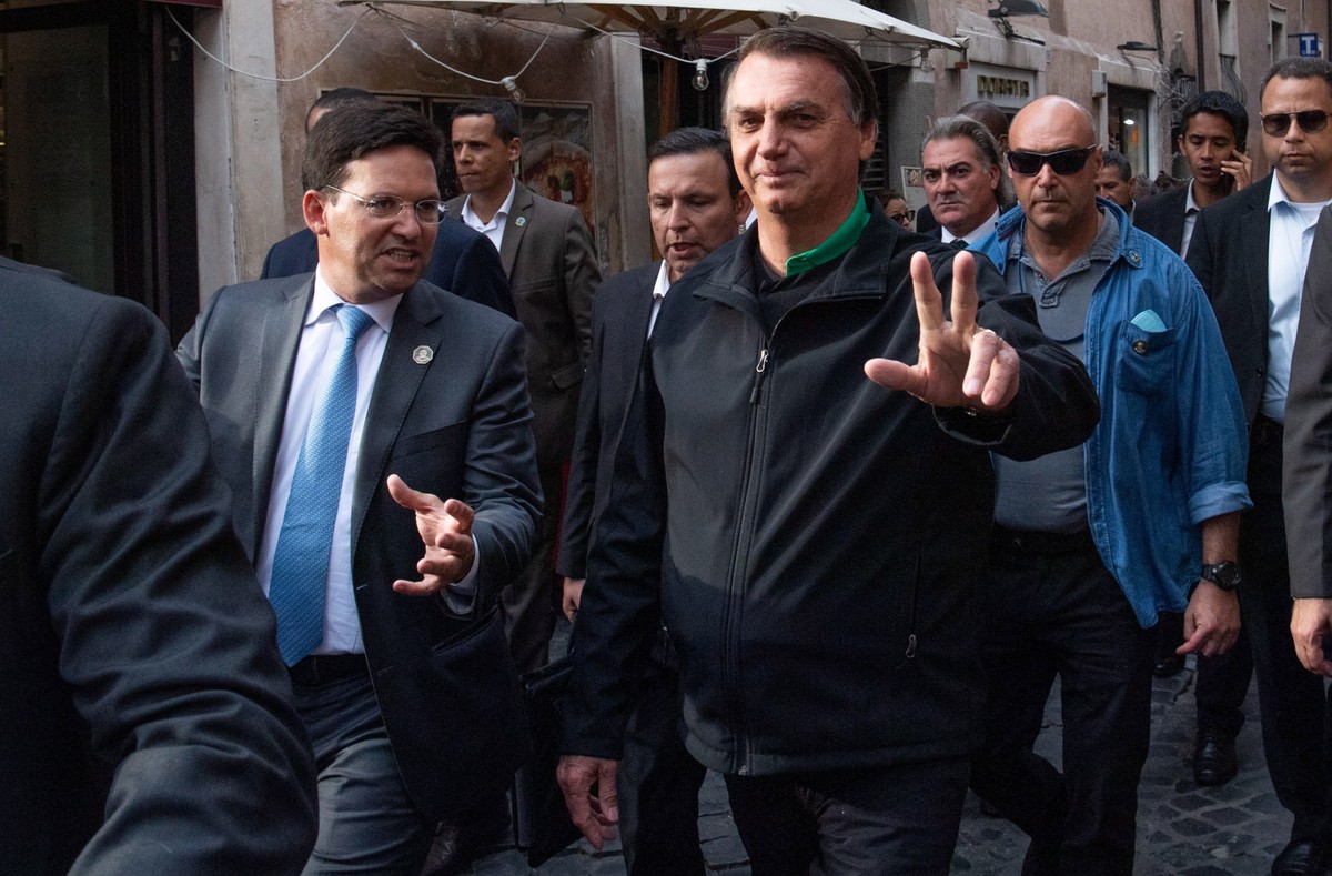 epa09552395 Brazil's President Jair Bolsonaro surrounded by his bodyguards, walks in the center of Rome, Italy, 29 October 2021. Bolsonaro arrived in Rome to attend G20 summit of world leaders to ...