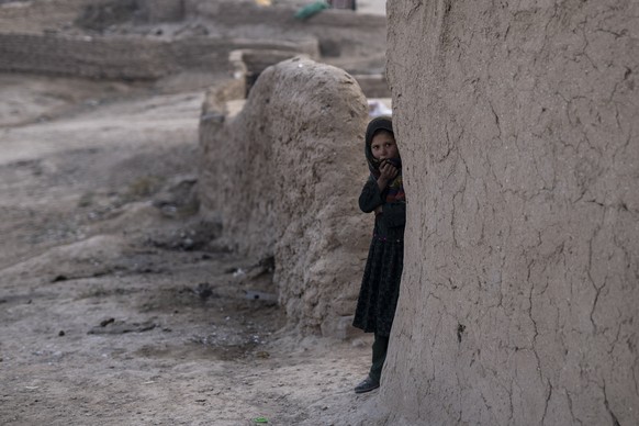 FILE - An Afghan girl looks out of her house in Kamar Kalagh village near Herat, Afghanistan, on Nov. 27, 2021. The United Nations is predicting that a record 274 million people
