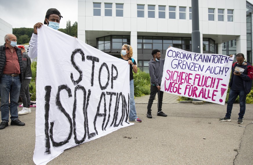 Demonstranten halten Transparente hoch, bei der Demonstration &quot;Stop Isolation&quot; vor dem Sitz des Staatssekretariats fuer Migration SEM, am Freitag, 25. Juni 2021, in Wabern bei Bern. (KEYSTON ...