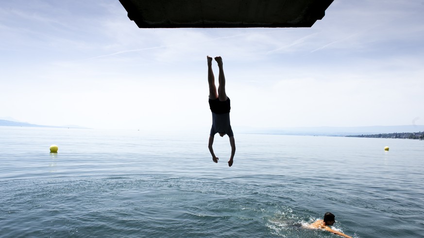 Children jump into the water of Lake Geneva play to cool off during the sunny and warm weather, in Lutry, Switzerland, Tuesday, June 25, 2019.The forecasts predict hot weather in Switzerland with the  ...