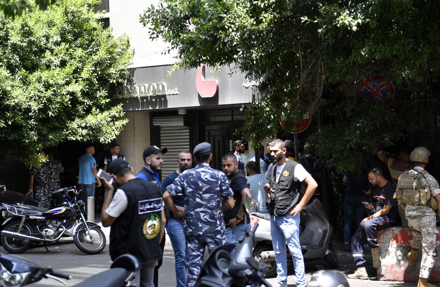 epa10115405 Lebanese security forces stand at the area of a bank in Hamra area where an armed man took clients and employees hostages, in Beirut, Lebanon, 11 August 2022. According to initial reports, ...