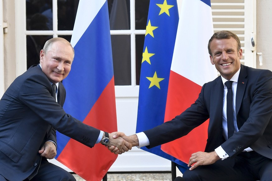 FILE - French President Emmanuel Macron, right, shakes hands with Russian President Vladimir Putin after their meeting at the fort of Bregancon in Bormes-les-Mimosas, southern France, on Aug. 19, 2019 ...