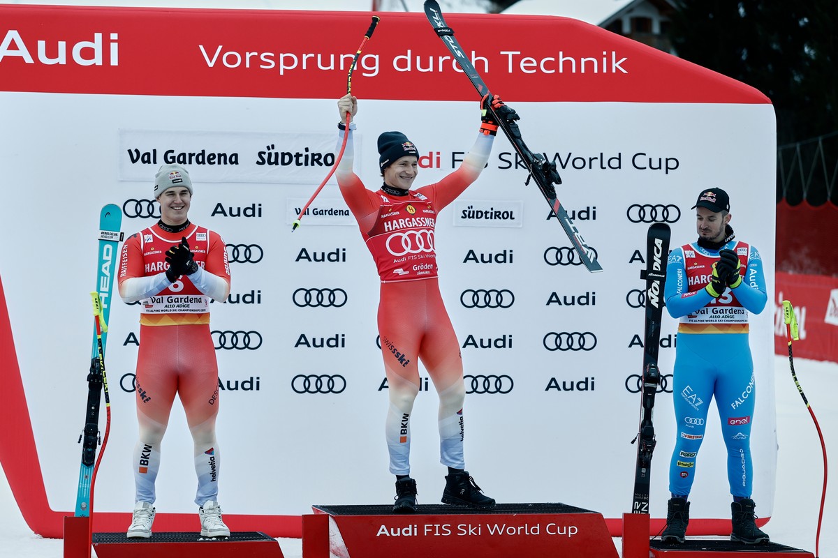Switzerland's Marco Odermatt,center, winner of an alpine ski, men's World Cup downhill, poses with second placed Switzerland's Franjo von Allmen, left, and third placed Italy's Dom ...