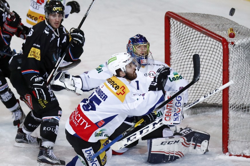 Biels Thomas Wellinger, vorne, und Biels Torhueter Jonas Hiller in Aktion, im Eishockey Meisterschaftsspiel der National League A zwischen dem HC Fribourg Gotteron und dem EHC Biel, am Freitag, 6. Jan ...