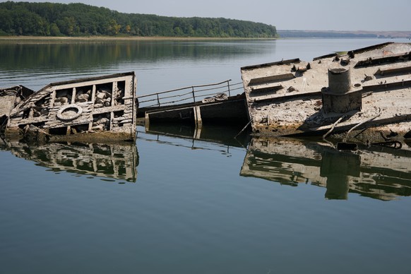 The wreckage of a WWII German warship emerges, due to the drought, in front of Djerdap II, a large dam on the Danube River, between Romania and Serbia, near Prahovo, Serbia, Tuesday, Aug. 4, 2026. (AP ...