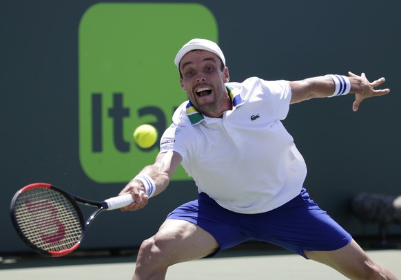 Roberto Bautista Agut, of Spain, hits a return to Sam Querry during the Miami Open tennis tournament, Monday, March 27, 2017, in Key Biscayne, Fla. (AP Photo/Lynne Sladky)