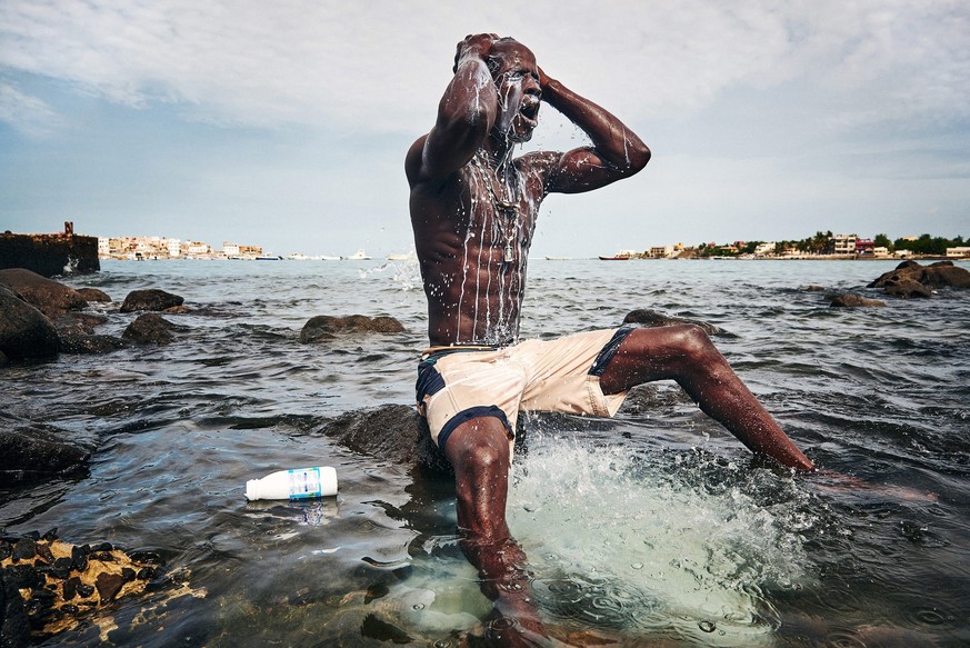 Preisgekrönte Schweizer Reportage: &nbsp;Ein junger Wrestler aus Senegal wäscht sich in einem Ritual gegen böse Geister mit Milch.