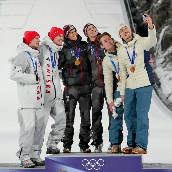 Gold medalists Stephan Embacher and Jan Hoerl, of Austria, celebrate on the podium, with silver medalists Pawel Wasek and Kacper Tomasiak, of Poland, and bronze medalists Kristoffer Eriksen Sundal and ...